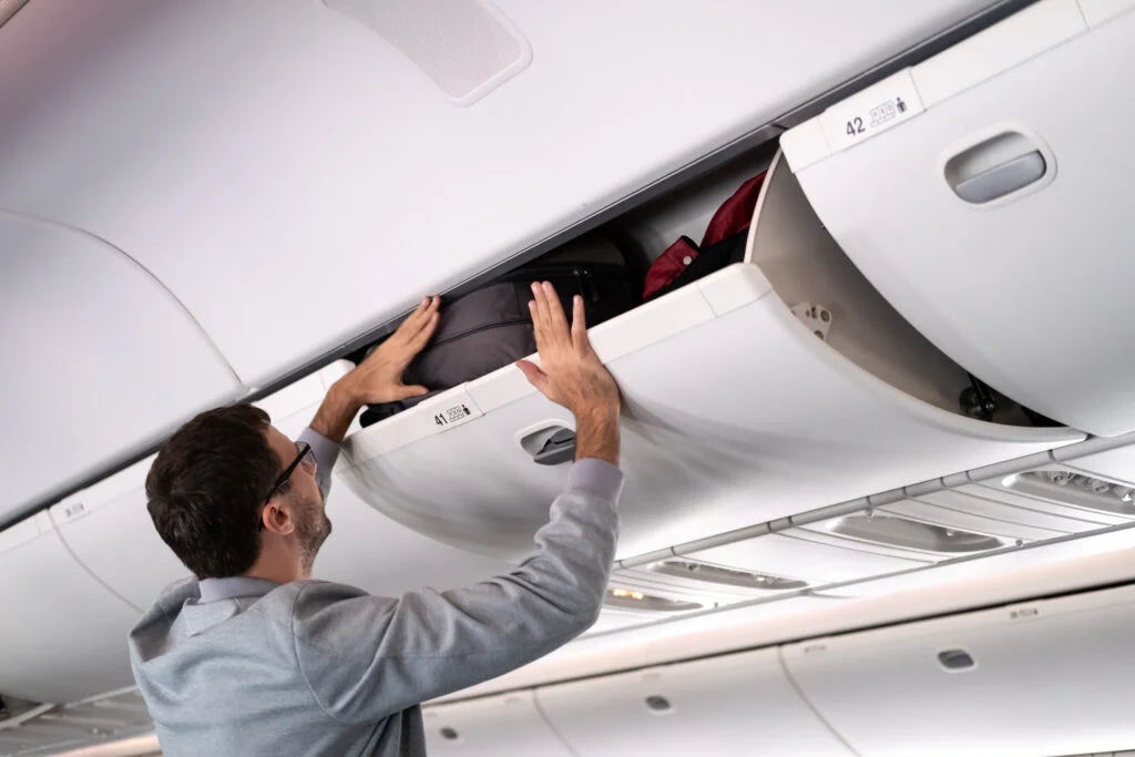 Hand-carry luggage being placed in an aircraft overhead compartment